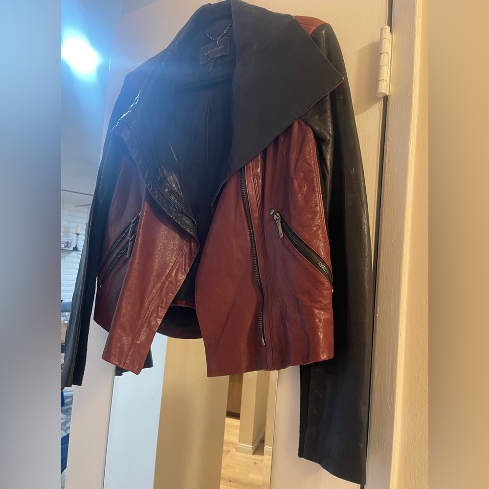 BCBGMaxazria black and burgundy hard leather jacket.